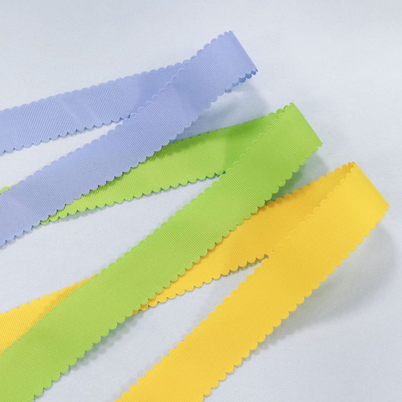 Detailansicht der gesägten Kante am Grosgrain-Band mit Spitzenbesatz